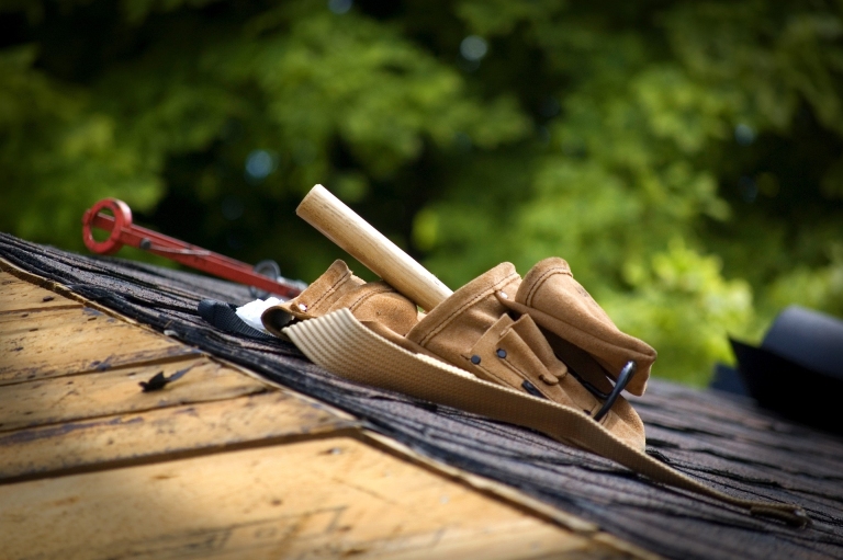 Wood mallet, chisels and a plane resting on a wooden beam